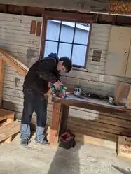 Everett using a saw at the work table