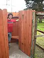 Robbie next to fencing with door