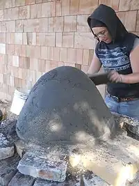 Fig.12 The sand dome is almost done. Jodi is compressing the sand by "tamping" it